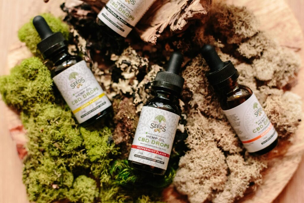 CBD oil bottles with droppers placed on a lush moss surface for organic product showcase.
