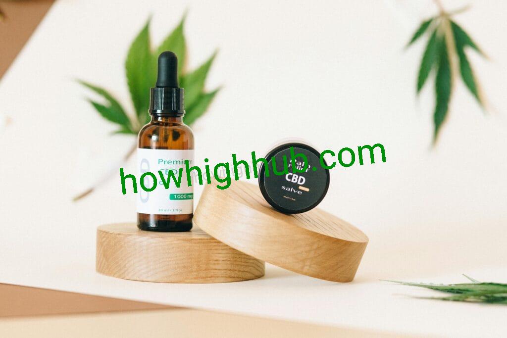 A premium CBD oil and pain relief salve set on wooden pedestals with a hemp leaf in the background.